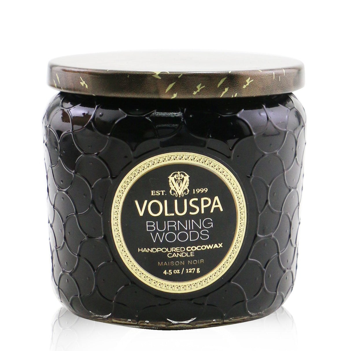 A petite jar candle with a luxurious coconut wax blend, featuring the warm scent of Burning Woods and an elegant glass container.