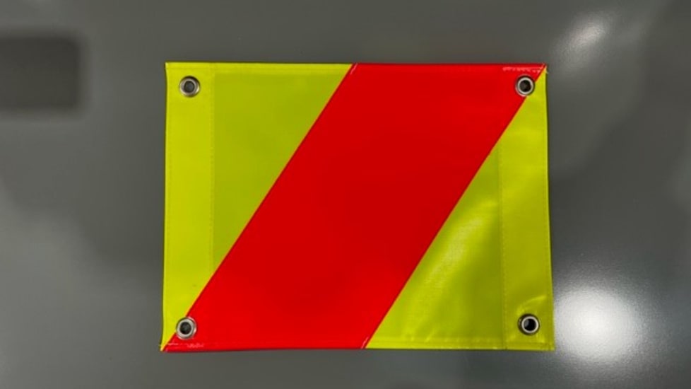 Bright hazard flag measuring W400mm x H300mm, featuring eyelets for secure attachment, ideal for marking oversized loads.