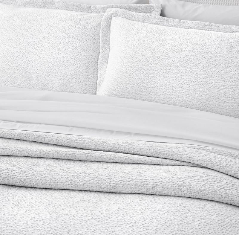 White stonewashed queen bedspread set with textured design and pillowcases, ethically made in Portugal by BAKSANA.