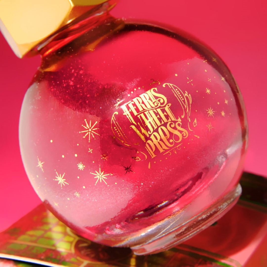 Glass globe containing Ferris Wheel Press Bumbling Blossom fountain pen ink, a duochrome rose-pink to green ink for creative writing.