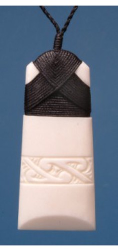 Engraved medium Toki pendant with intricate Maori design, symbolizing strength, on a black wax cord for adjustable wear.