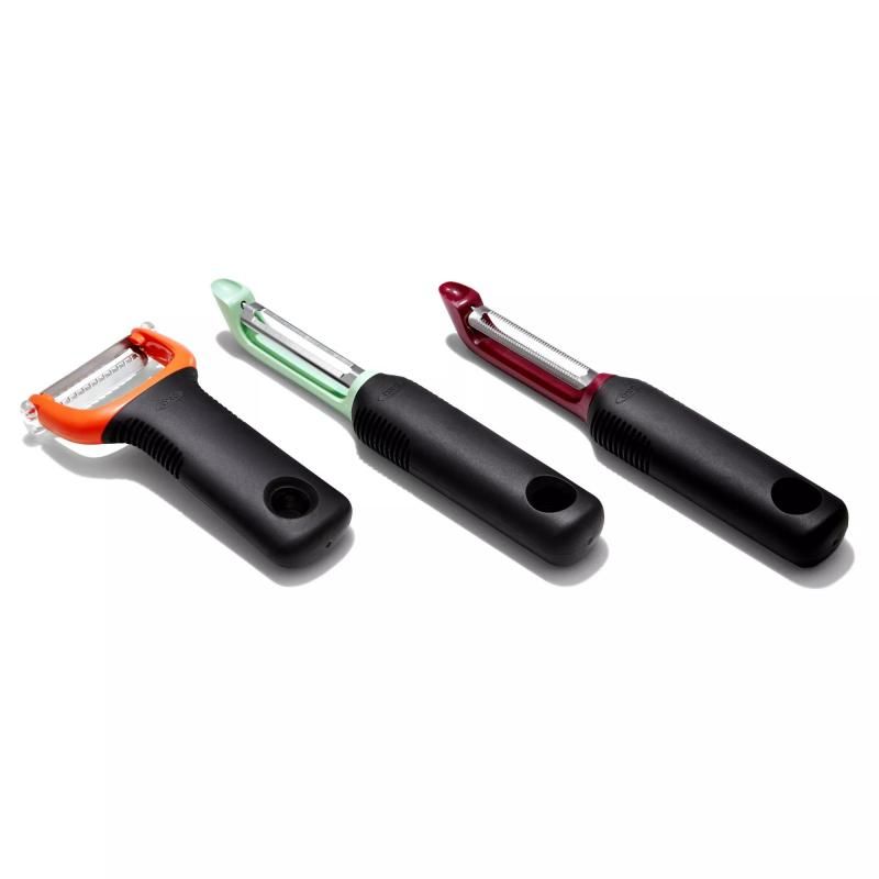 Three OXO peelers featuring sharp stainless steel blades and ergonomic handles, perfect for effortless vegetable and fruit prep.