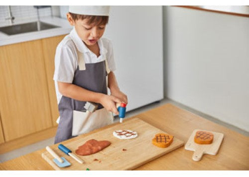 Wooden PlanToys Chef Set with utensils and ingredients for imaginative play, promoting creativity and eco-friendly values.