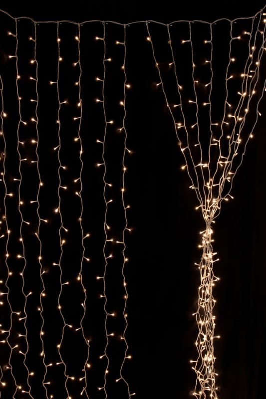 Warm white LED curtain lights (600 count) with 8 functions; ideal for creating a cozy, decorative ambiance.