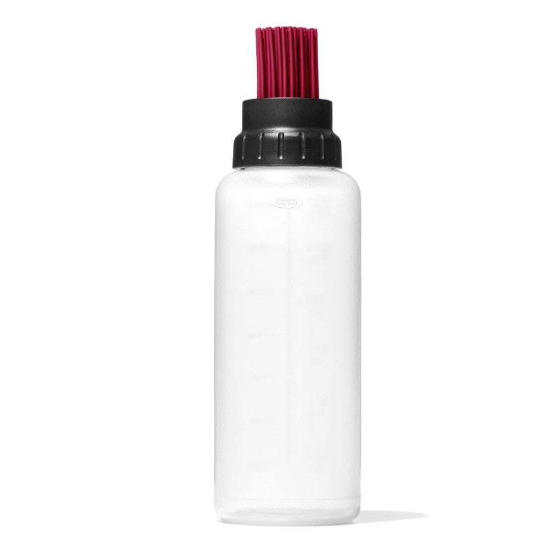 Silicone basting bottle with valve, tall collar to prevent drips, and measurement markings for easy sauce application.