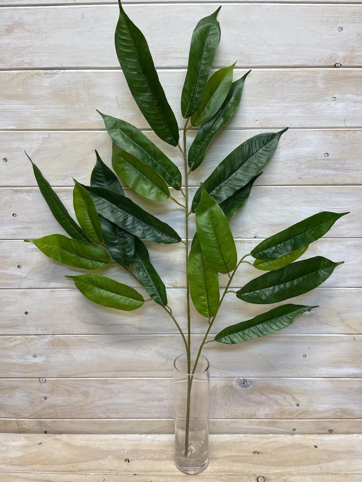 Lifelike long green mango leaf spray for vibrant tropical decor, perfect for arrangements and low-maintenance greenery.