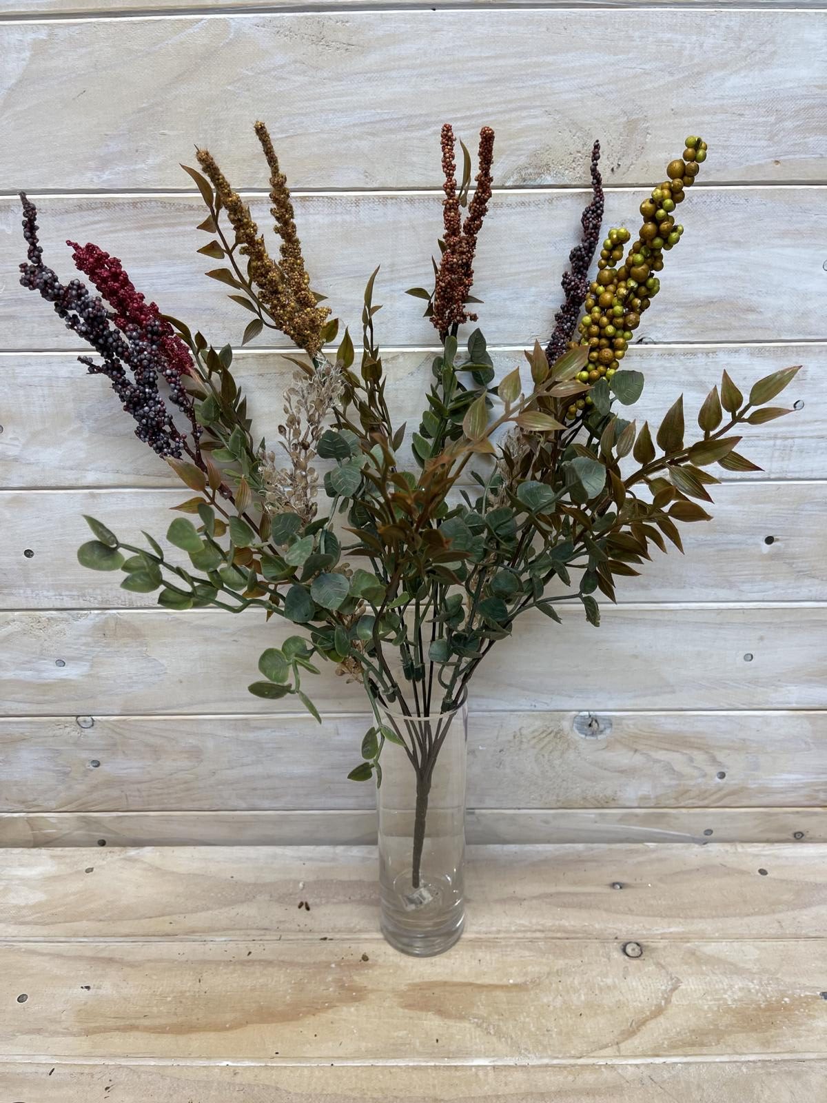 A vintage-inspired artificial flower bush in rich autumn hues of yellow, orange, and brown for year-round decor.