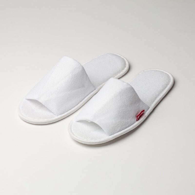 Open toe cotton slippers in white terry, padded for comfort, with rubber soles for non-slip safety; perfect for relaxation at home.