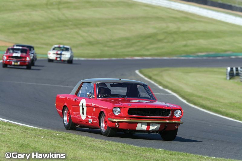 Alt text: "Scalextric Goodwood Mustang #8 in striking red and gold, commemorating iconic motorsport heritage and thrilling racing."
