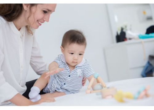 Colorful triangle-shaped clutching toy made of sustainable rubberwood, promoting fine motor skills and sensory exploration for babies.