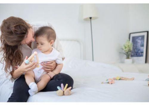 Colorful triangular clutching toy made of eco-friendly rubberwood, designed for sensory play and fine motor skill development in infants.