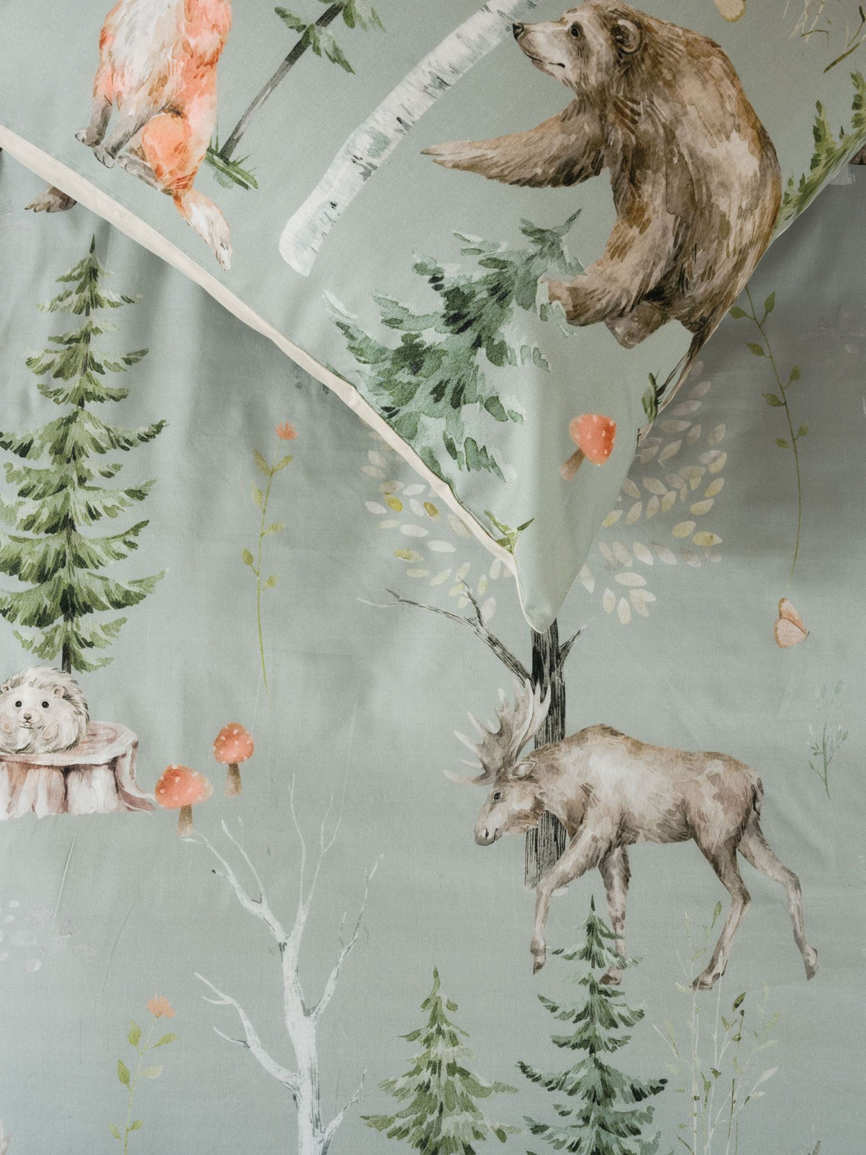 Single duvet cover set featuring whimsical woodland animals on sage green cotton fabric, promoting a soothing sleep environment.
