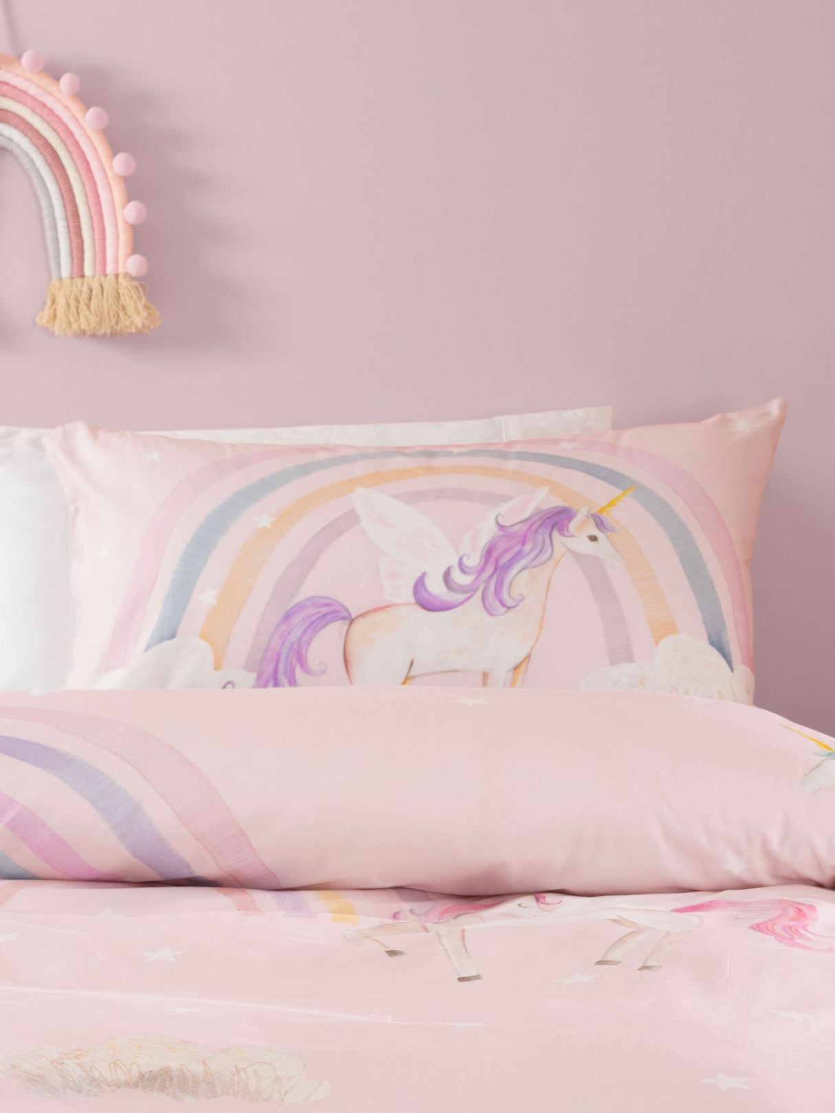 Single duvet cover set featuring hand-drawn unicorns, rainbows, and clouds on a pink backdrop for a magical bedroom.