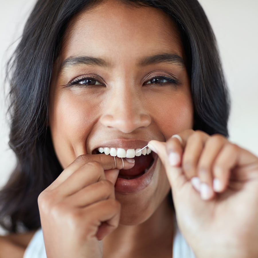 Mint-flavored Colgate Total Dental Floss for tartar control, easily sliding between teeth for improved gum health and plaque removal.