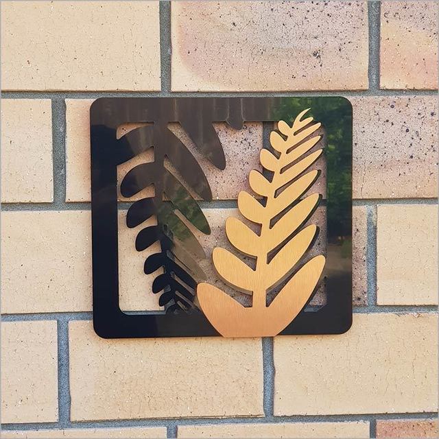 Two-tone fern art panels in brushed copper and black, perfect for indoor/outdoor decor, embodying Kiwiana charm.