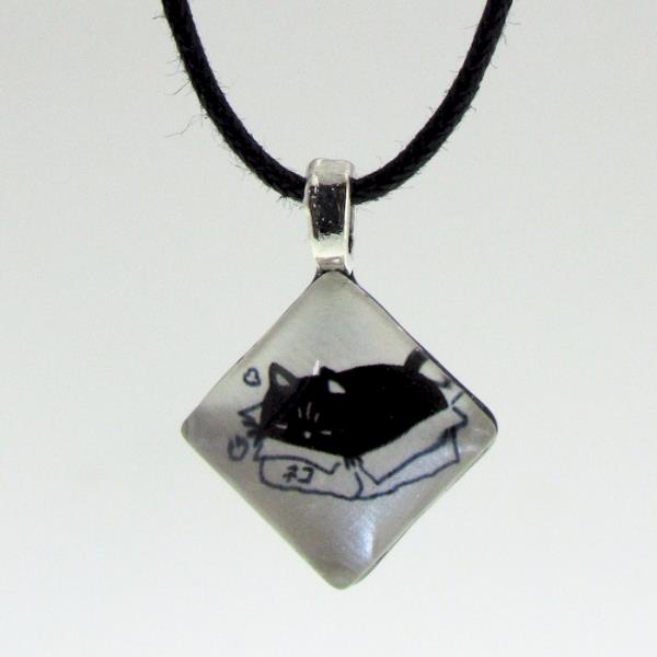 Whimsical hand-crafted diamond-shaped glass pendant featuring a cheeky cat design on an adjustable cord necklace.