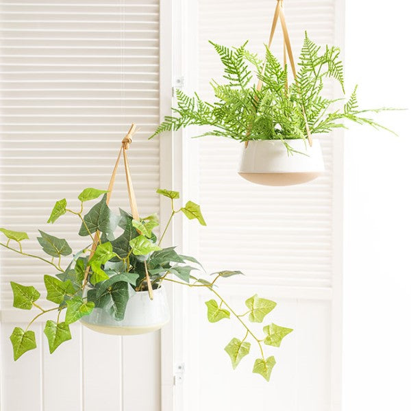 Elegant white ceramic dolomite hanging planter duo, perfect for displaying plants with modern sophistication.