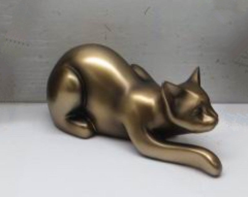 Gold lying cat ornament made of poly resin, featuring detailed craftsmanship; ideal for home decor and cat lovers.