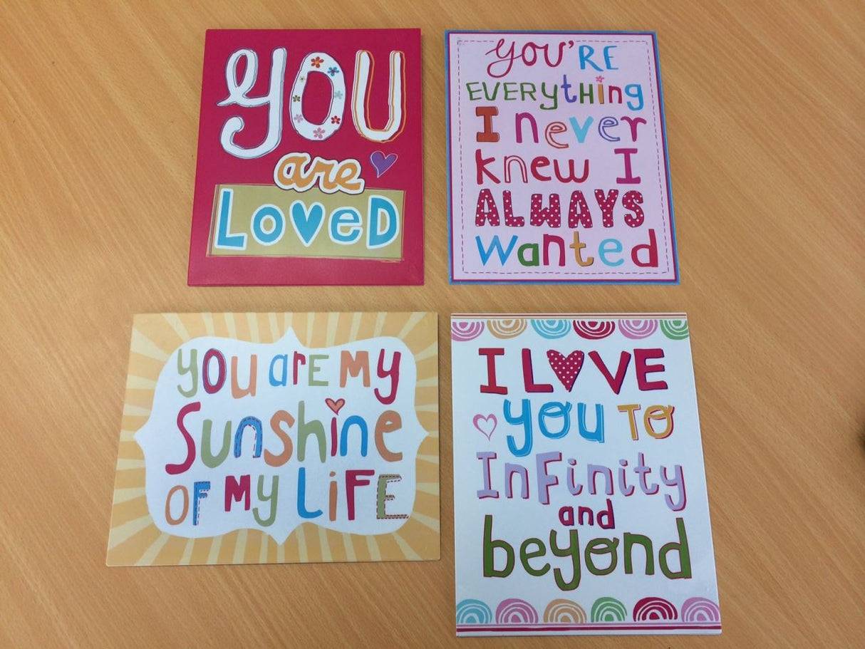 Set of 4 charming metal wall plaques featuring motivational quotes, perfect for brightening any room's decor.