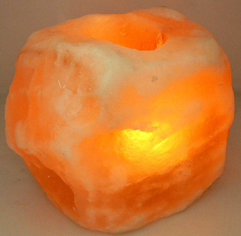 Himalayan salt lamp and tealight holder, 8cm diameter, emits a warm glow for relaxation and air purification.