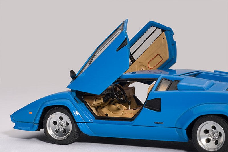 Diecast model of Lamborghini Countach 5000S in blue, featuring opening doors and detailed engine, perfect for collectors.