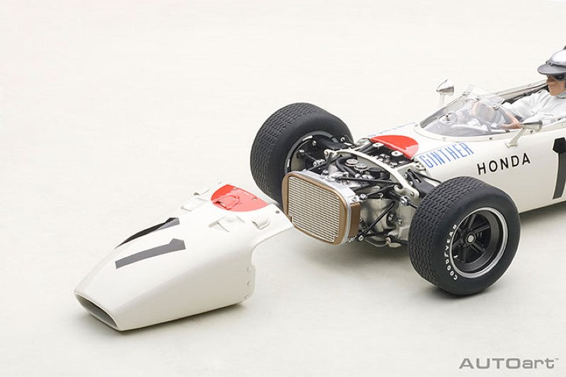 Diecast model of the 1965 Honda RA272 #11, featuring detailed design, vibrant paint, opening hood, and driver figure.