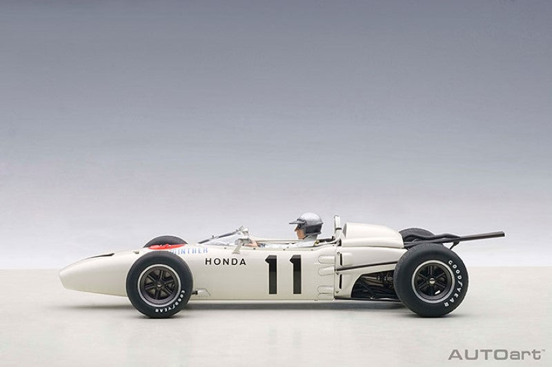 Diecast model of the '65 Honda RA272 #11, featuring vibrant paint, driver figure, and opening hood for collectors.