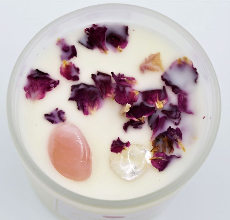 Soy wax candle in pink with Rose Quartz and Clear Quartz crystals, featuring a champagne scent and 40 hours of burn time.