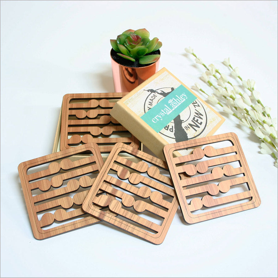 Kiwiana coasters crafted from Rimu wood, featuring intricate koru patterns, perfect for home decor or as a thoughtful gift.