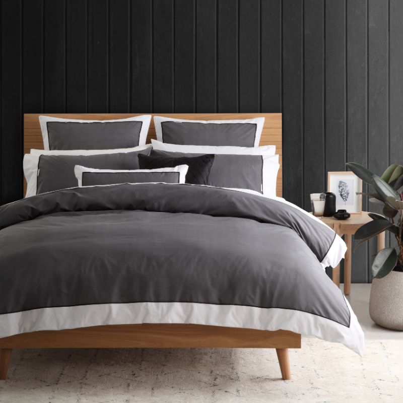 Double duvet cover set in charcoal with herringbone pattern, white trim, and black piping for a sophisticated bedroom look.