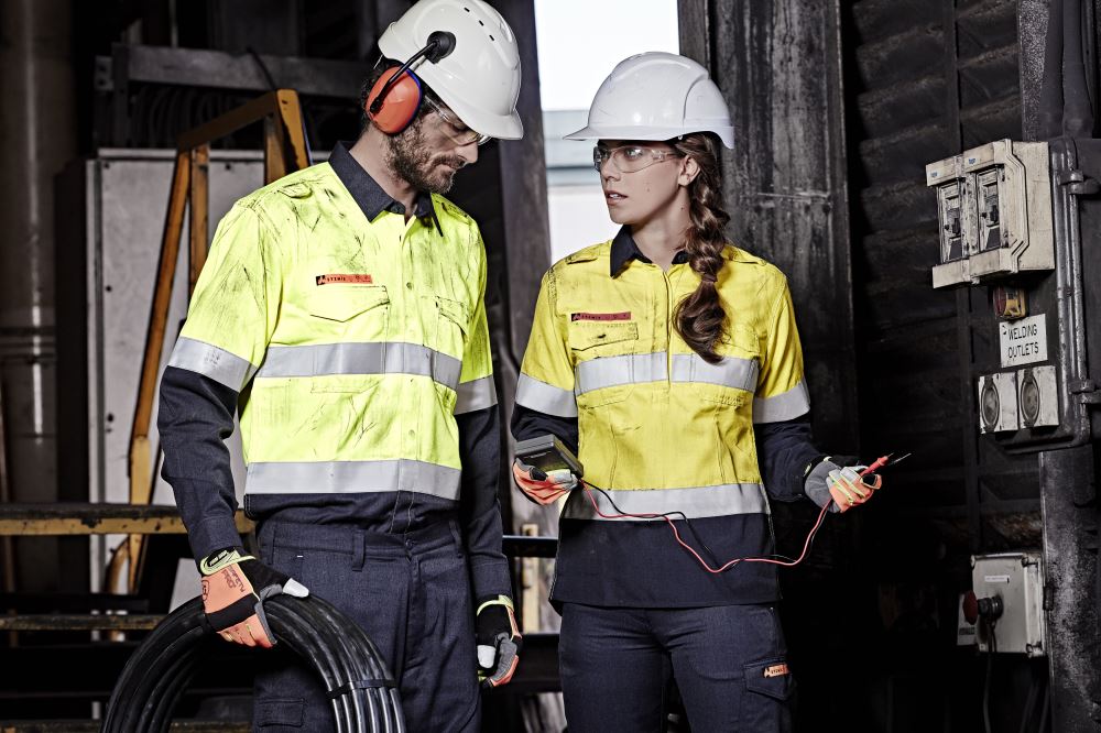 Women's orange and navy flame-resistant shirt with closed front, gusset sleeves, and ventilation for safety and comfort.