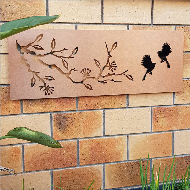 Large two-tone copper and black wall art featuring a pohutukawa tree and fantail bird, perfect for indoor or outdoor decor.