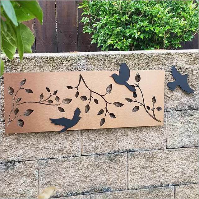 Large wall art panel featuring brushed copper branches and three movable black acrylic birds, suitable for indoor/outdoor decor.