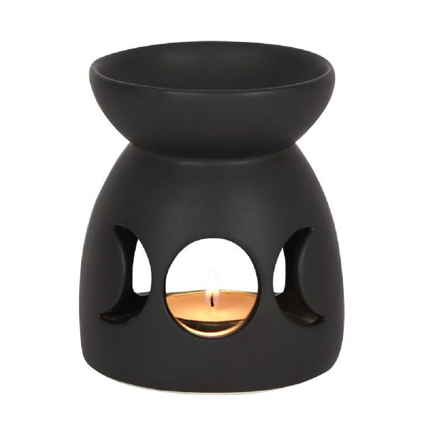 Black ceramic oil burner with triple moon cut-out, designed for aromatherapy; ideal for relaxation and spiritual ambiance.