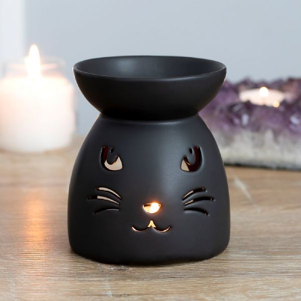Black ceramic oil burner with a cut-out cat face, perfect for Halloween and compatible with fragrance oils and wax melts.