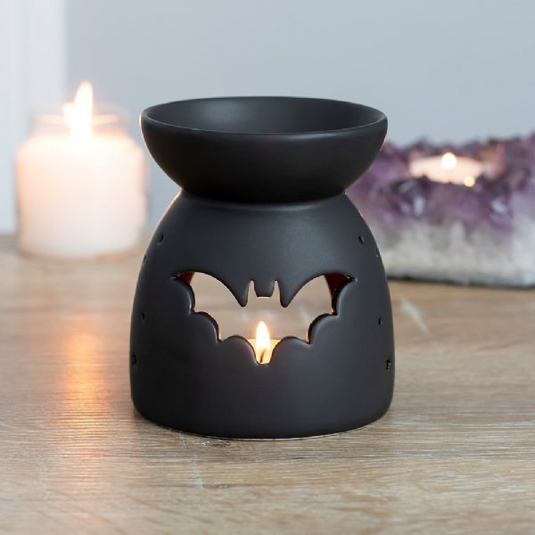 Black ceramic oil burner with bat cut-out design, perfect for Halloween decor and creating cozy aromas. H:10 x W:9 x D:9 cm.