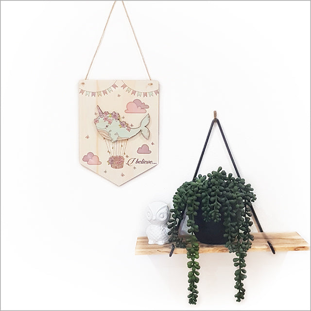 Whimsical narwhal wall art flag in eco-friendly pine, featuring 'I Believe' message for playful decor.