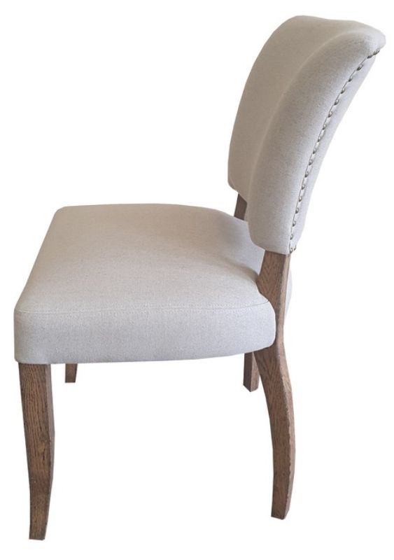 Elegant dining chair with natural linen upholstery, oak legs, and brass studs, blending rustic charm with modern luxury.