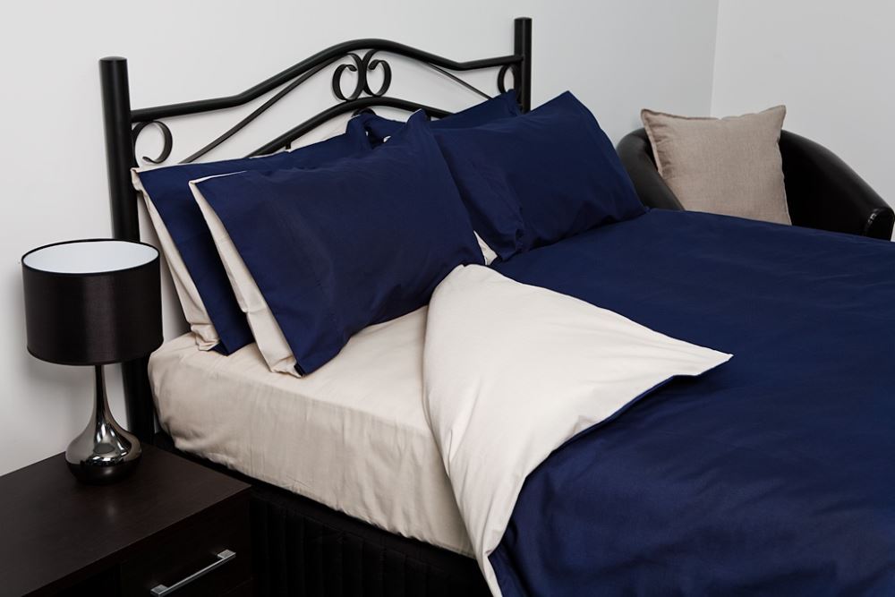 Reversible king duvet cover in vibrant blue and elegant oyster, crafted from a soft polyester-cotton blend for durability.