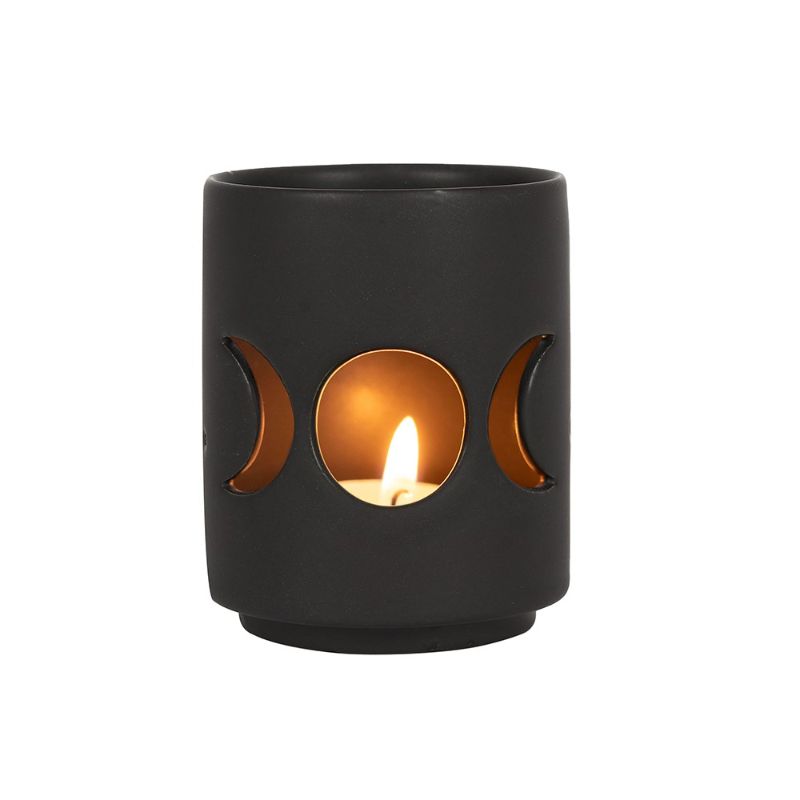 Small black ceramic tealight holder featuring triple moon cut-out design, perfect for adding mystical ambiance to any space.