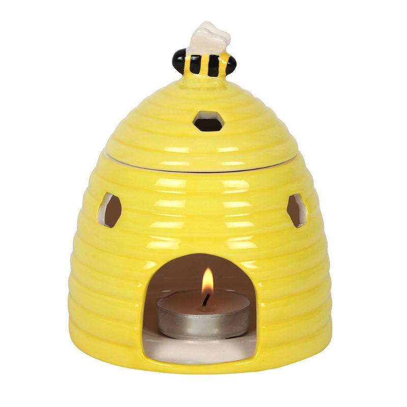 Charming yellow beehive oil burner with bee lid and honeycomb cutouts, perfect for aromatherapy and home decor.