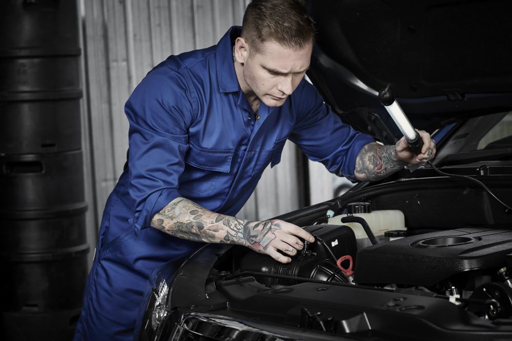 Durable Syzmik men's service overall in charcoal with elastic waist, multiple pockets, and heavy-duty construction for trades.