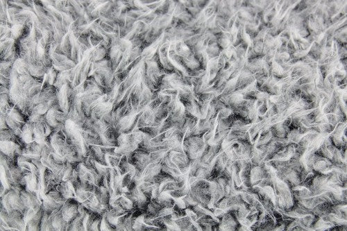 Luxurious double-sided faux sheep throw in black with white ends, perfect for cozying up and enhancing home decor.