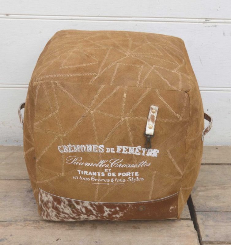 Stylish buffalo leather ottoman with unique stitching, perfect as a footrest or accent table in any room.