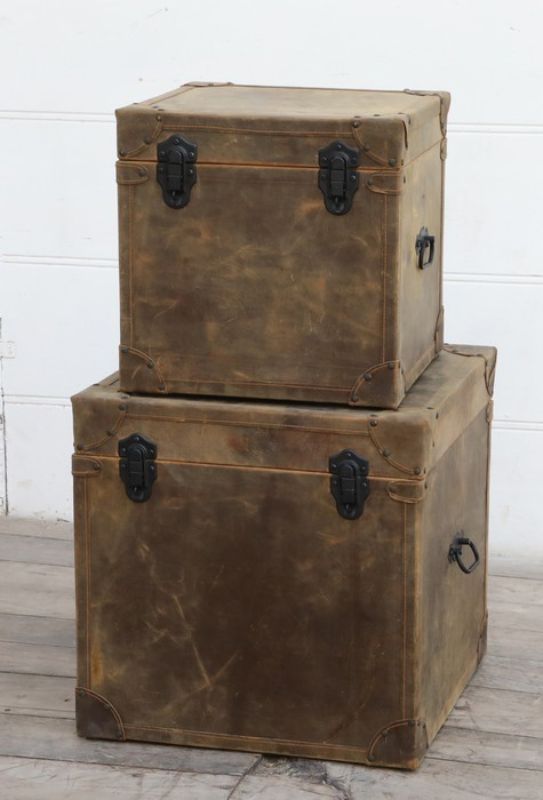Set of 2 vintage leather trunks with earthy tones, robust frame, and metal clasps, perfect for stylish home storage.