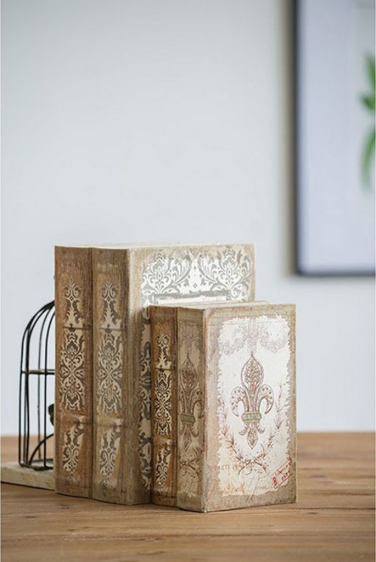 Set of 4 decorative book-shaped storage boxes made from linen and MDF, perfect for organizing keepsakes and displaying on a shelf.