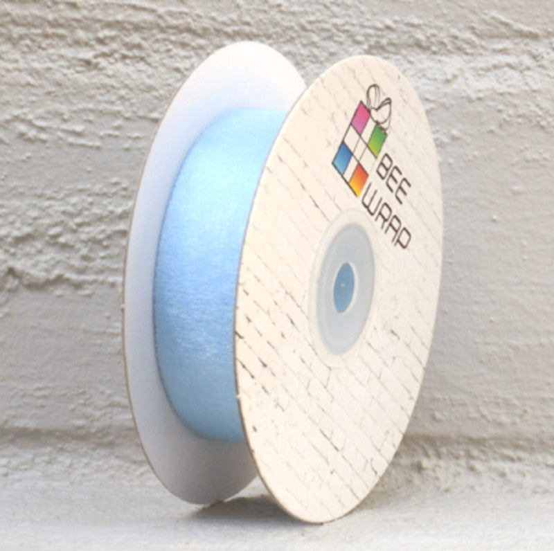 Pale blue organza ribbon, 25mm wide and 50m long, perfect for elegant gift wrapping and crafting.