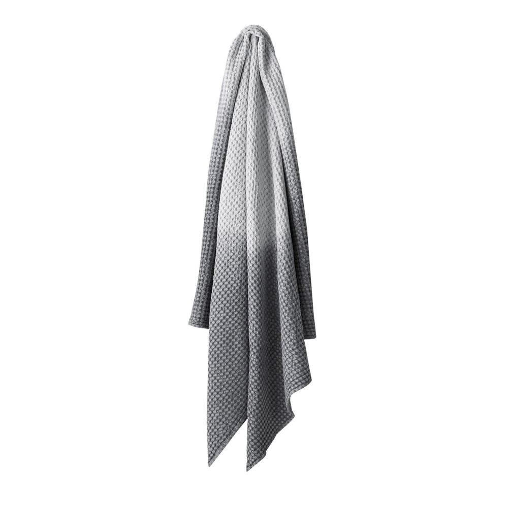 Hand dip dyed cotton throw, 140 x 200 cm, in smoke color with a waffle texture by Aura.