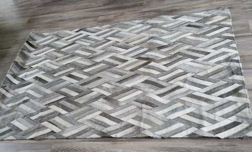 Handmade cowhide leather rug featuring a unique zigzag pattern, 1.32 x 1.99m with felt backing for stability and comfort.
