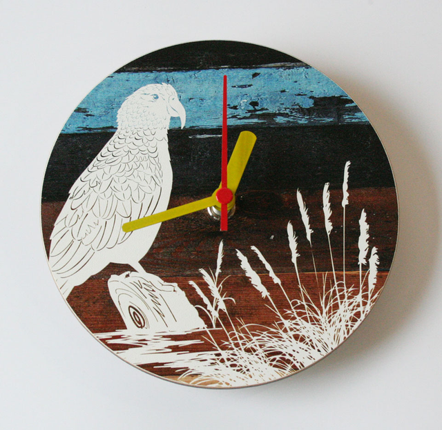 A round wall clock featuring a colorful illustration of a Kea bird, crafted from durable printed MDF, measuring 150 mm.